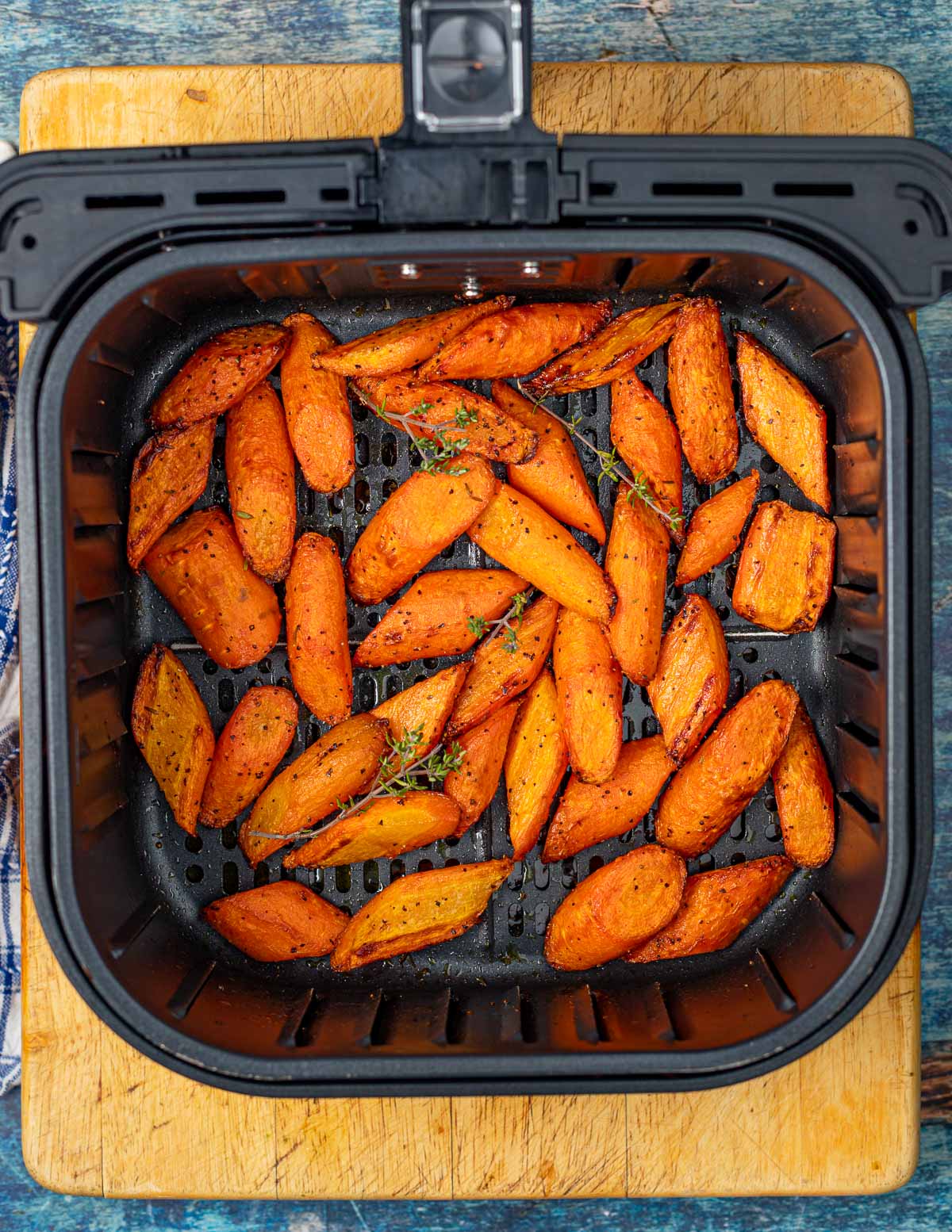 cooked carrots in an air fryer basket