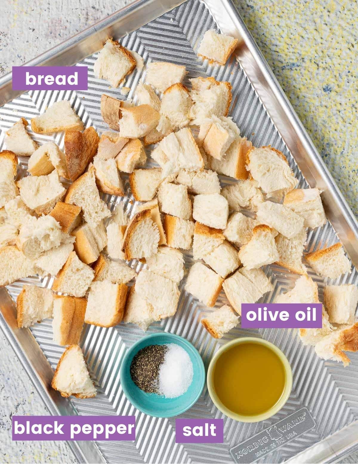 bread cubes, olive oil & salt & pepper on a baking tray 