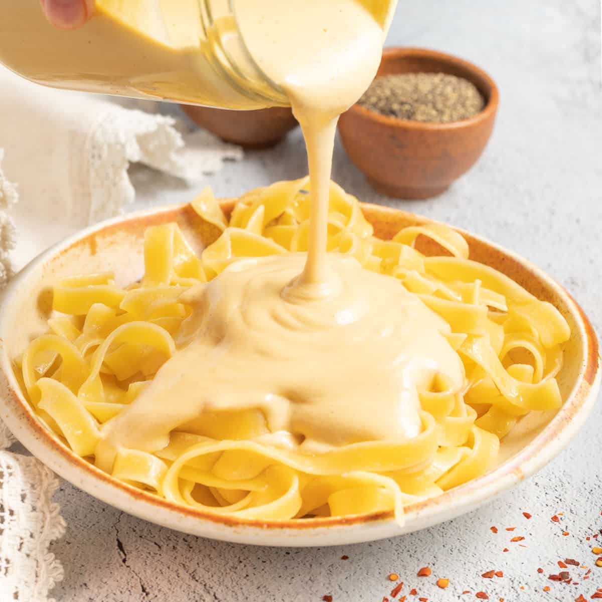 fettuccine with cheese sauce pouring over