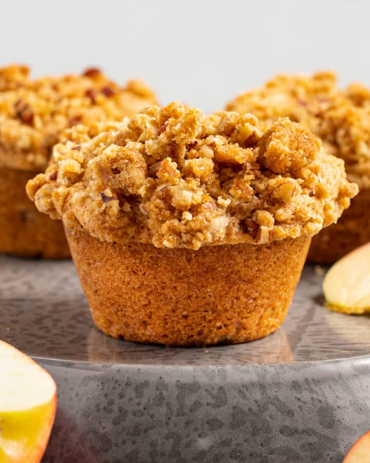 vegan apple muffins with fresh apple pieces scattered around