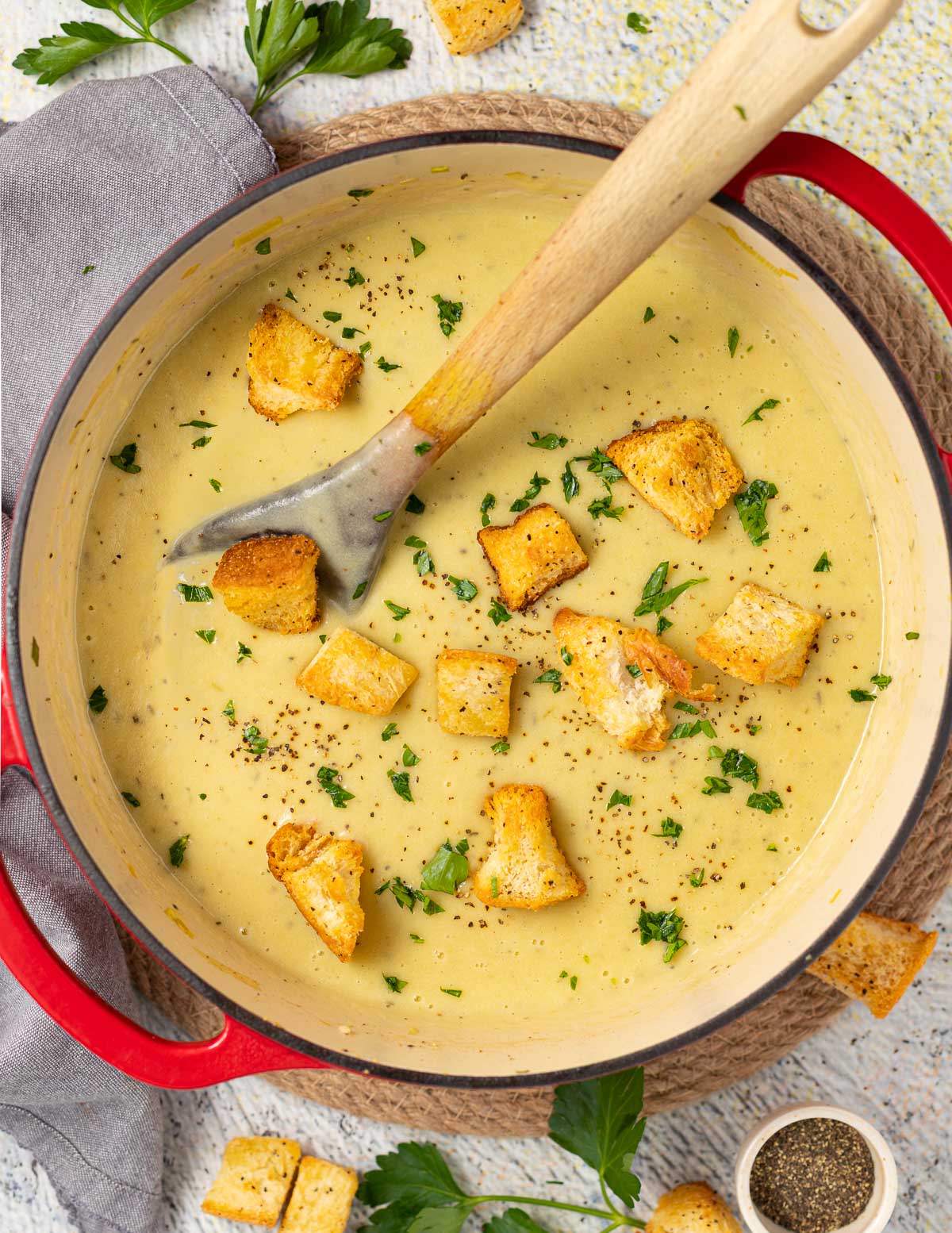 a large pan of vegan soup with croutons and parsley