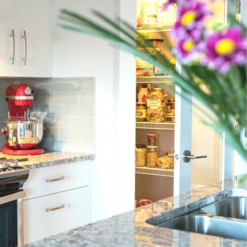 a light bright kitchen with an open pantry door