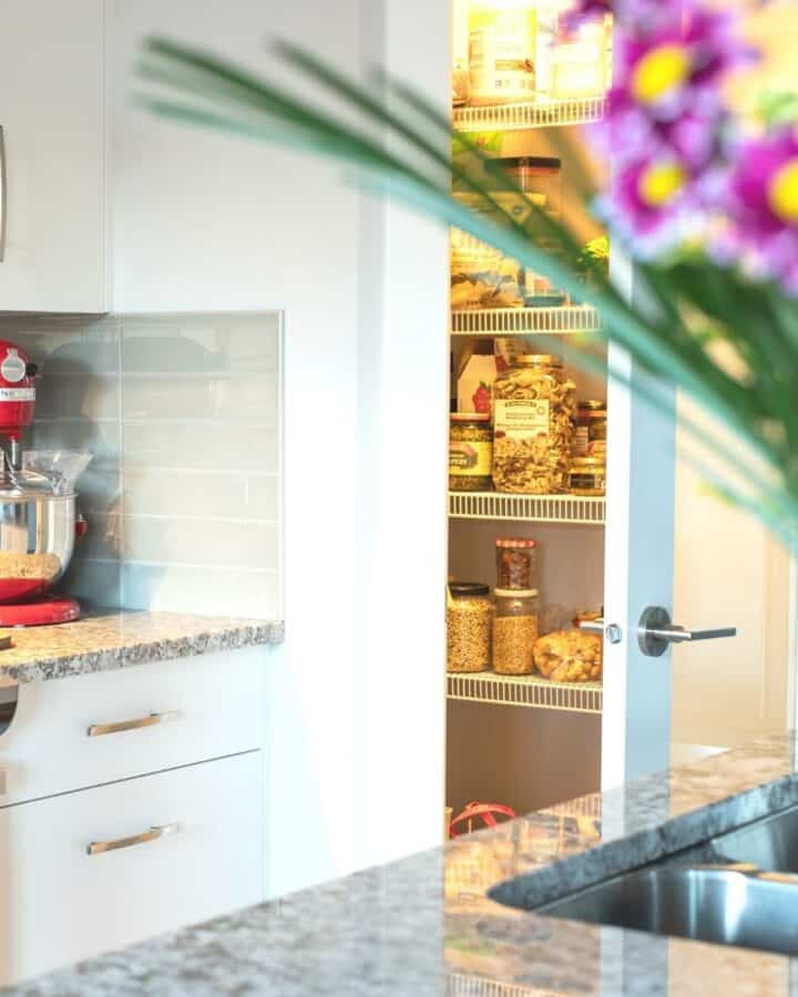 a light bright kitchen with an open pantry door