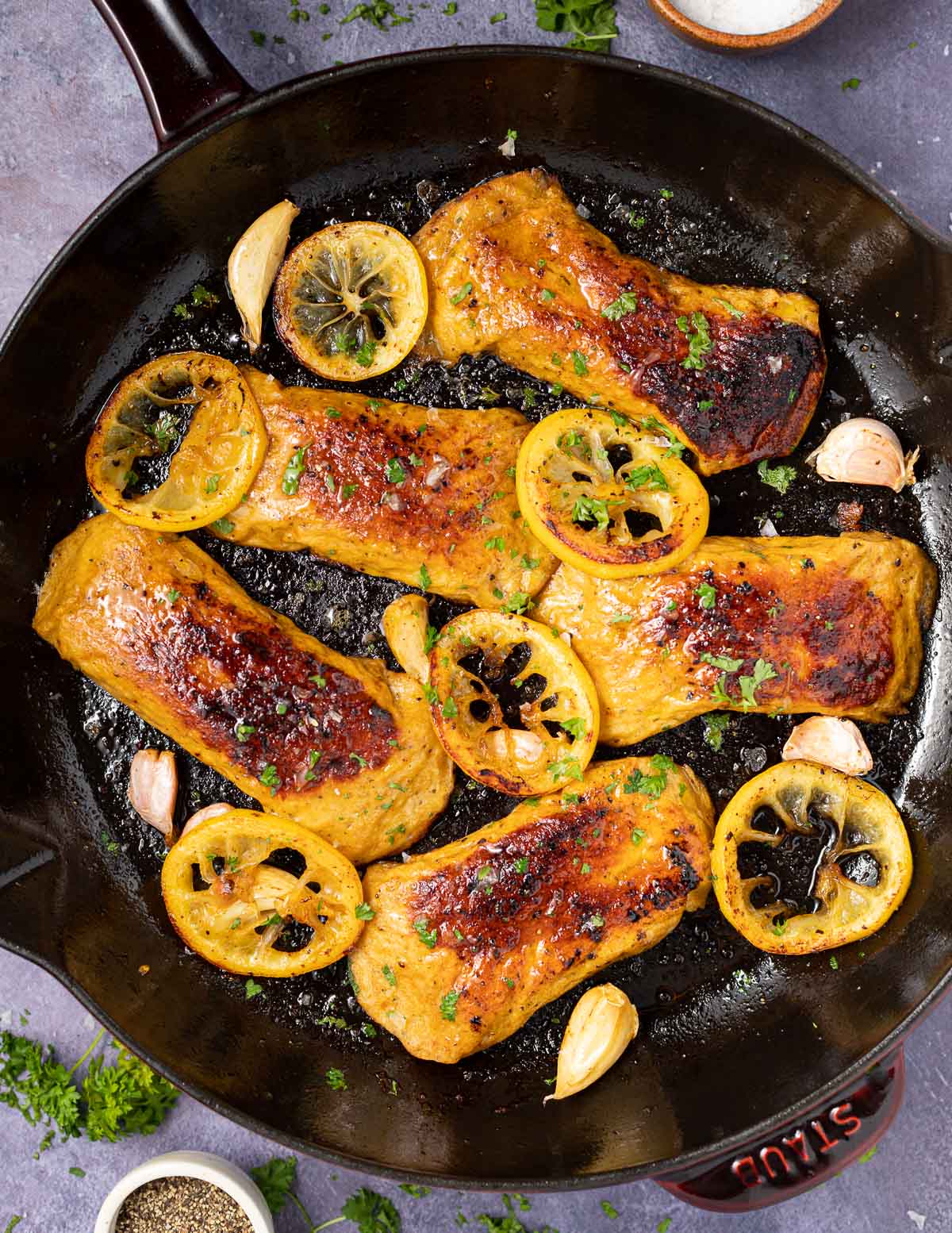 vegan chicken breasts in a pan with lemon slices & garlic