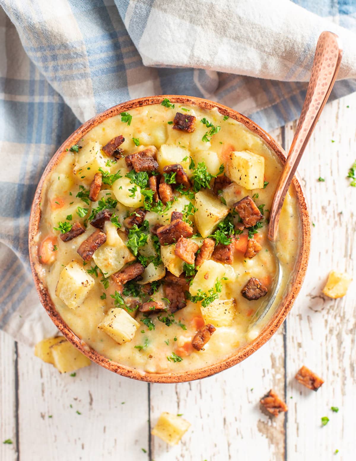 a bowl of vegan potato soup with toppings