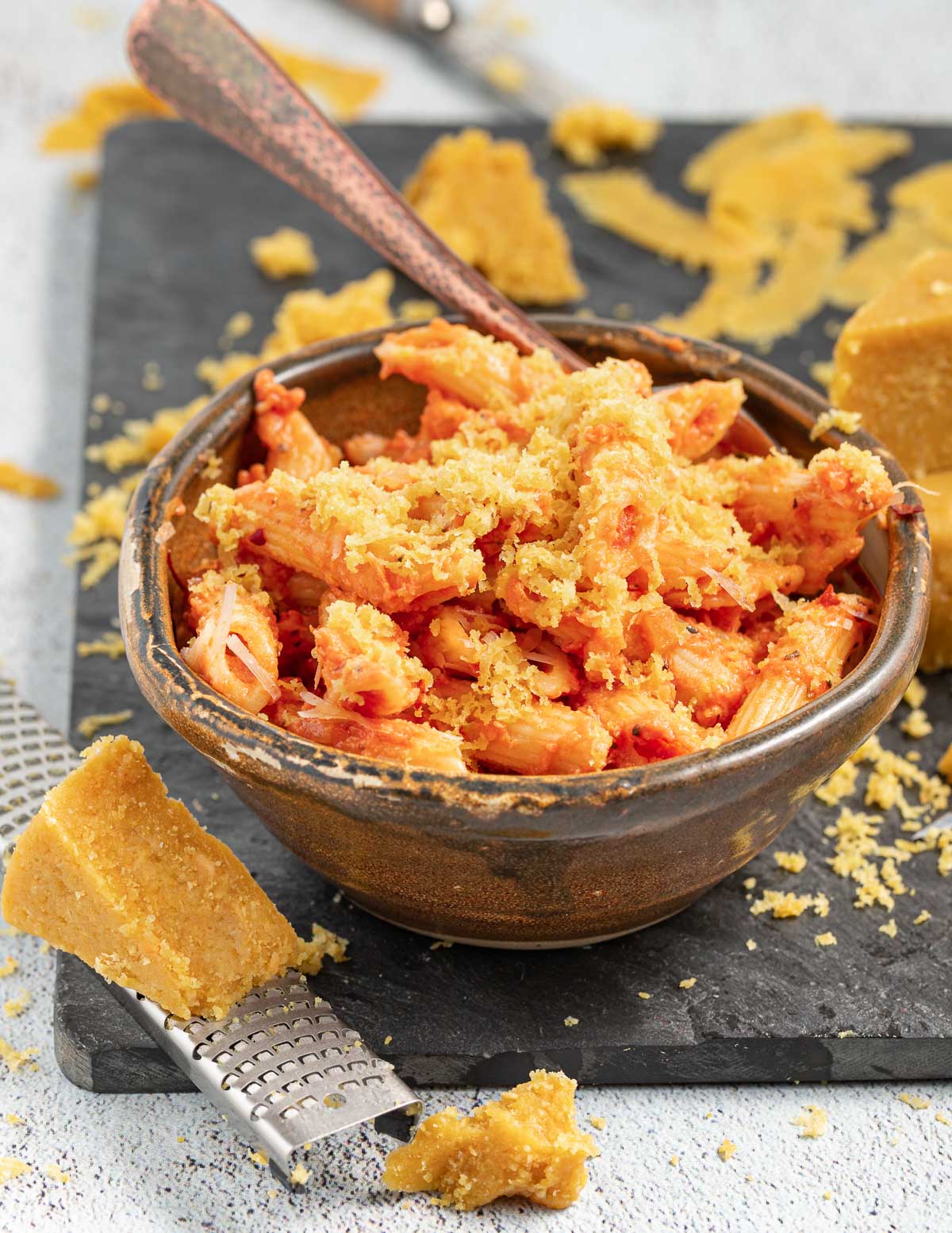 a bowl of pasta with vegan parmesan grated on it 