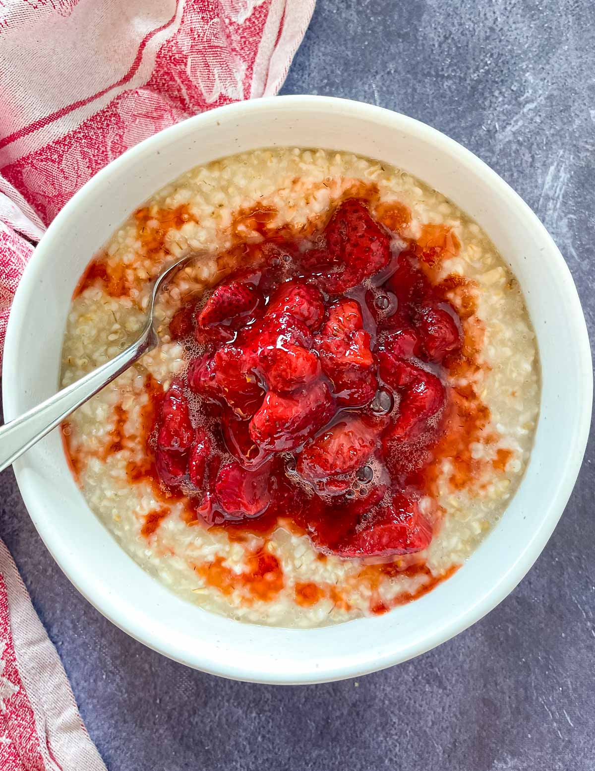 a bowl of oatmeal topped with roasted strawberries