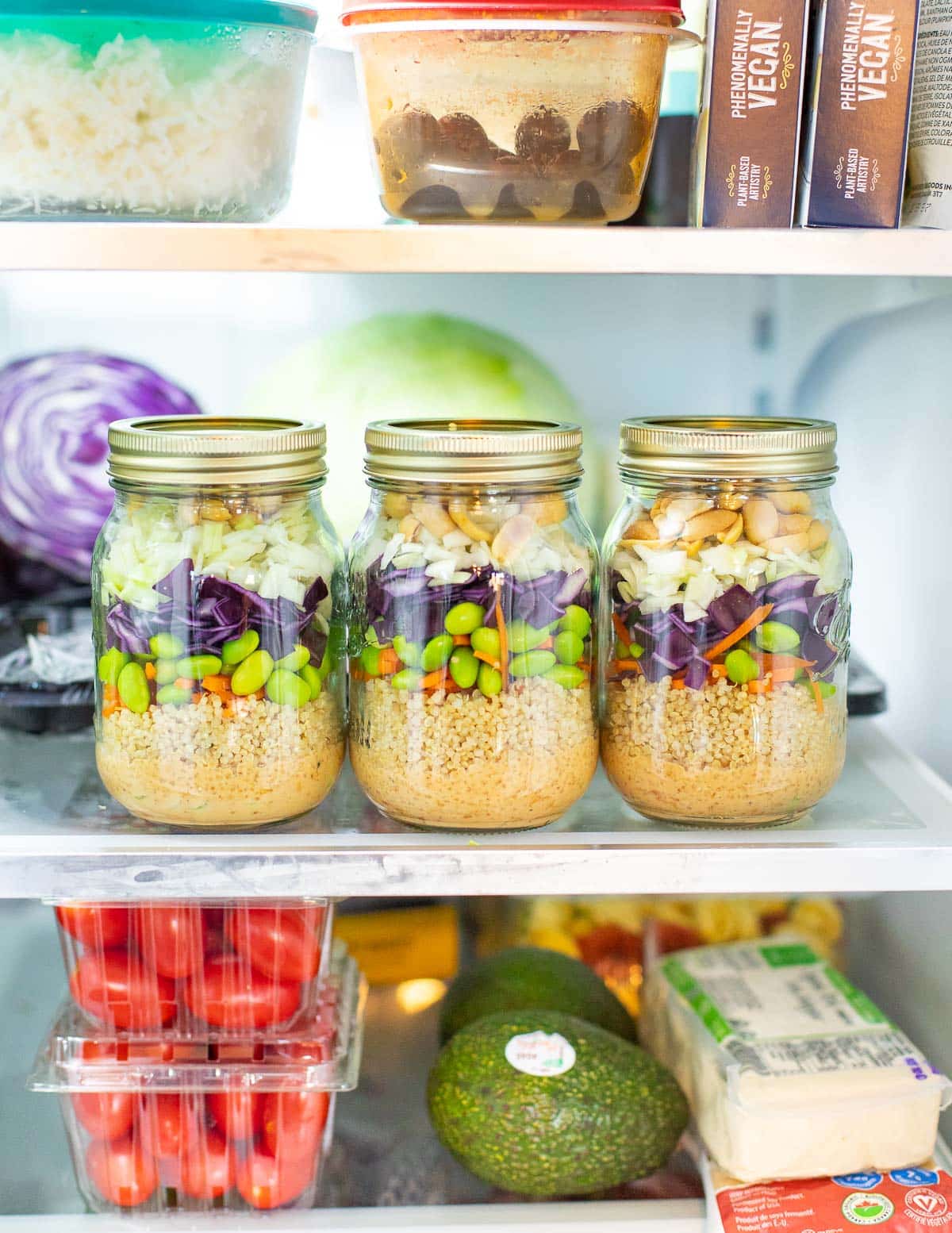 jars of salad on a shelf in a fridge