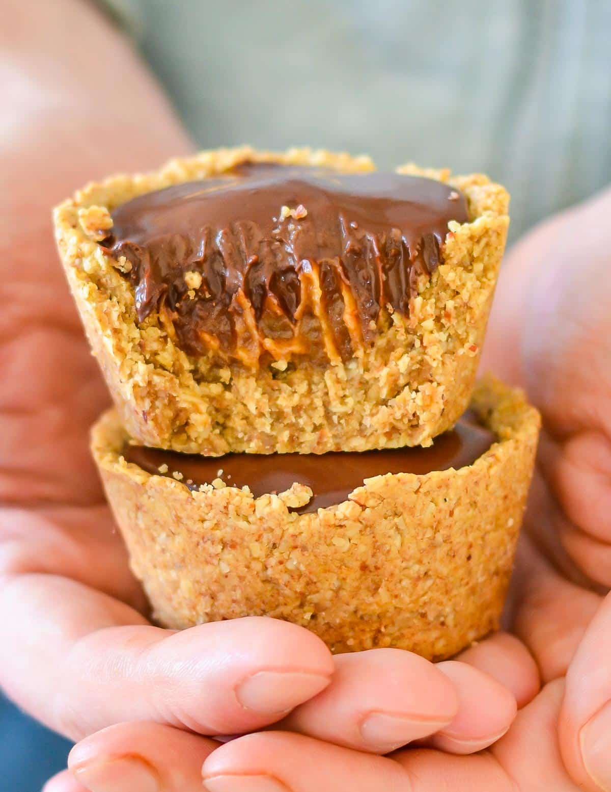 a stack of chocolate caramel cookie cups in a hand