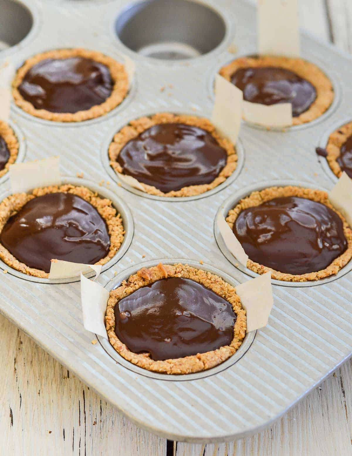 chocolate caramel cookie cups in a muffin pan
