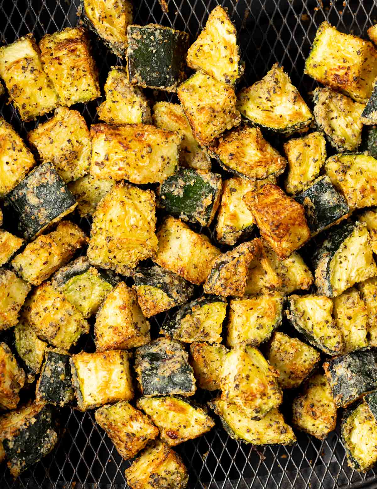 close up of crispy zucchini pieces in an air fryer