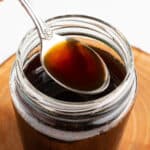 a spoonful of brown sugar syrup held over a jar of syrup