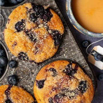 close up of 2 blueberry muffins in a vintage pan