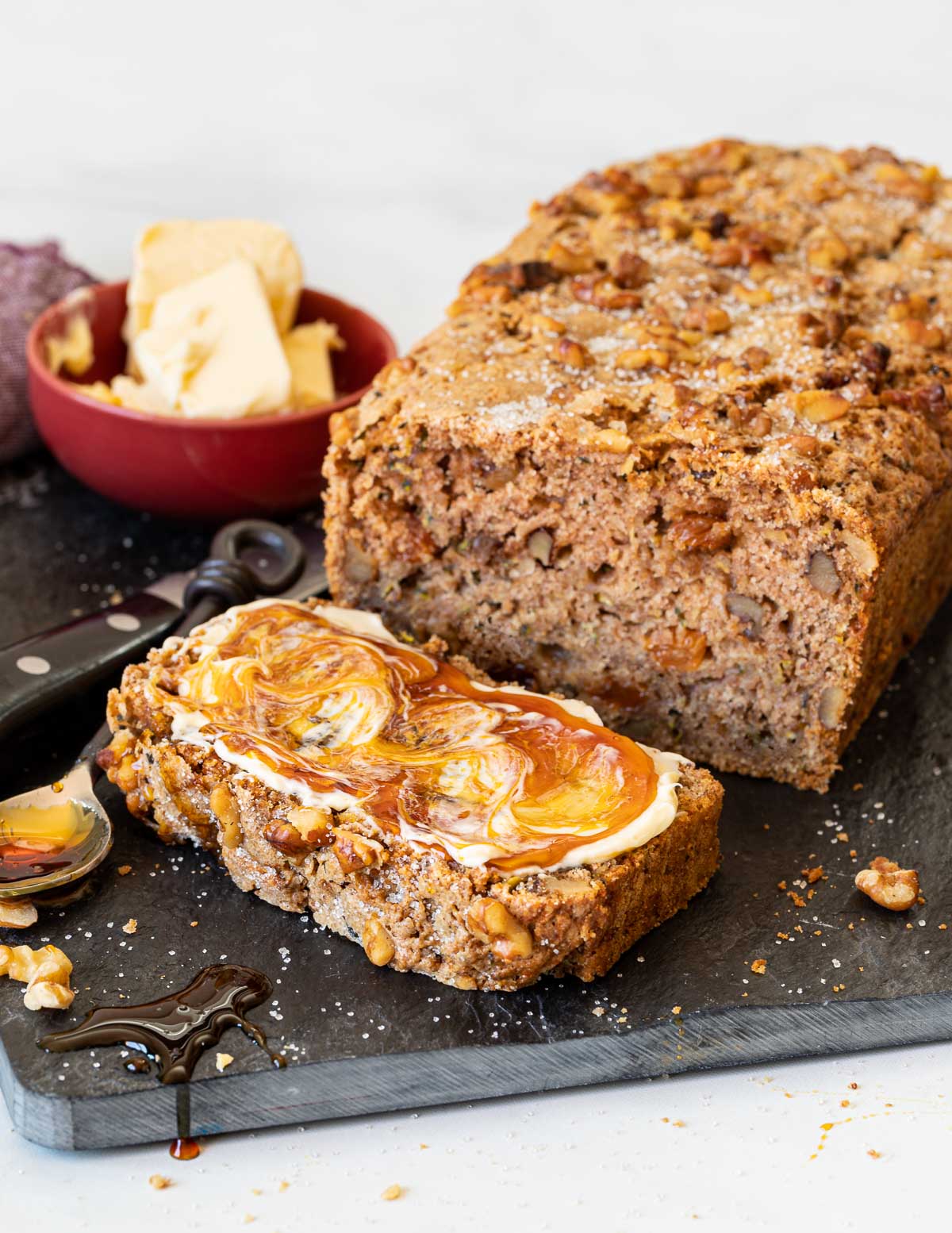 vegan zucchini bread sliced and spread with vegan butter and vegan honey 