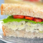 a sandwich filled with white bean artichoke sandwich filling, lettuce and tomato