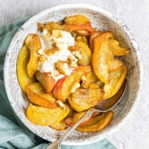 a bowl of air fryer apples with yogurt and walnuts