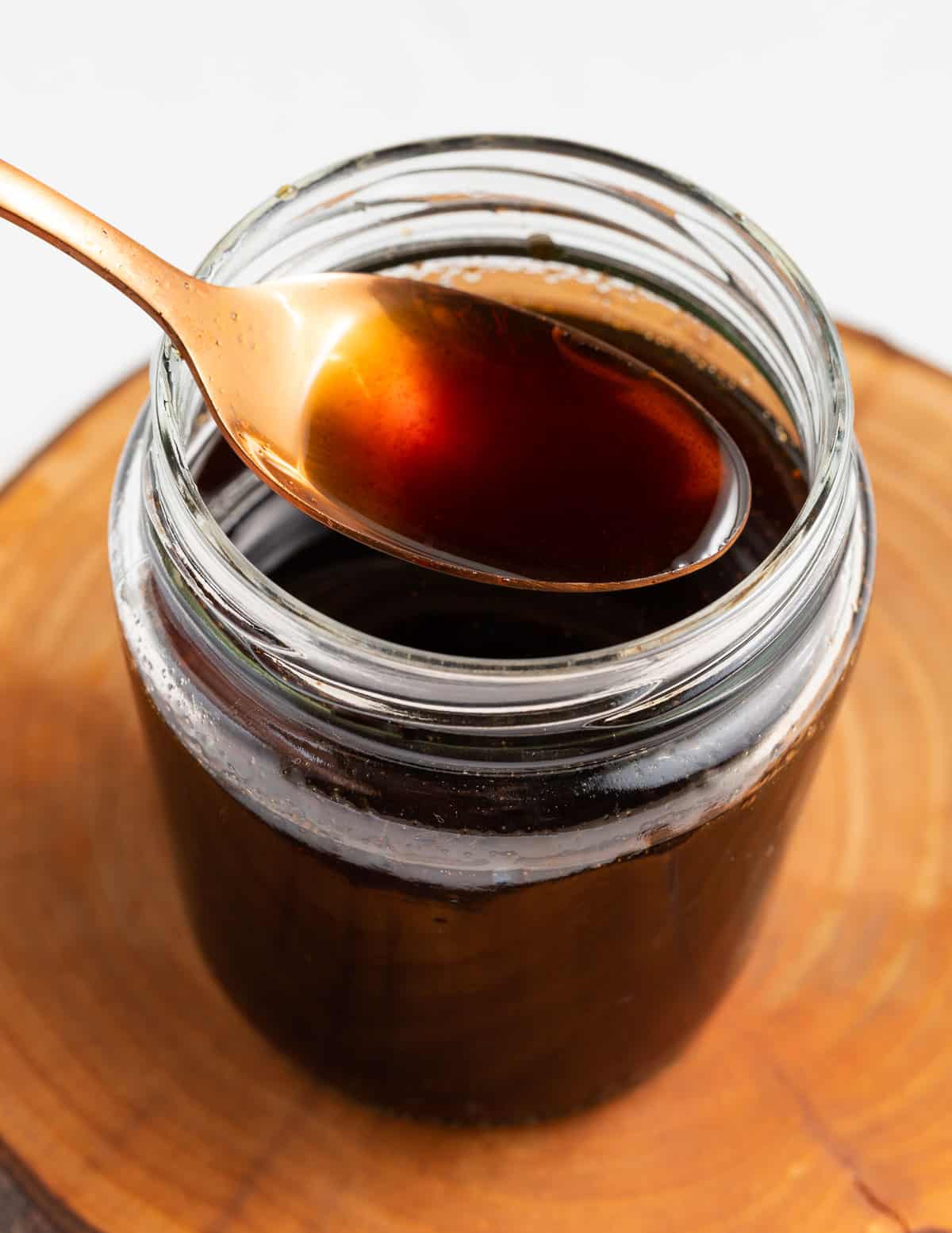 a jar of apple brown sugar syrup with a spoon