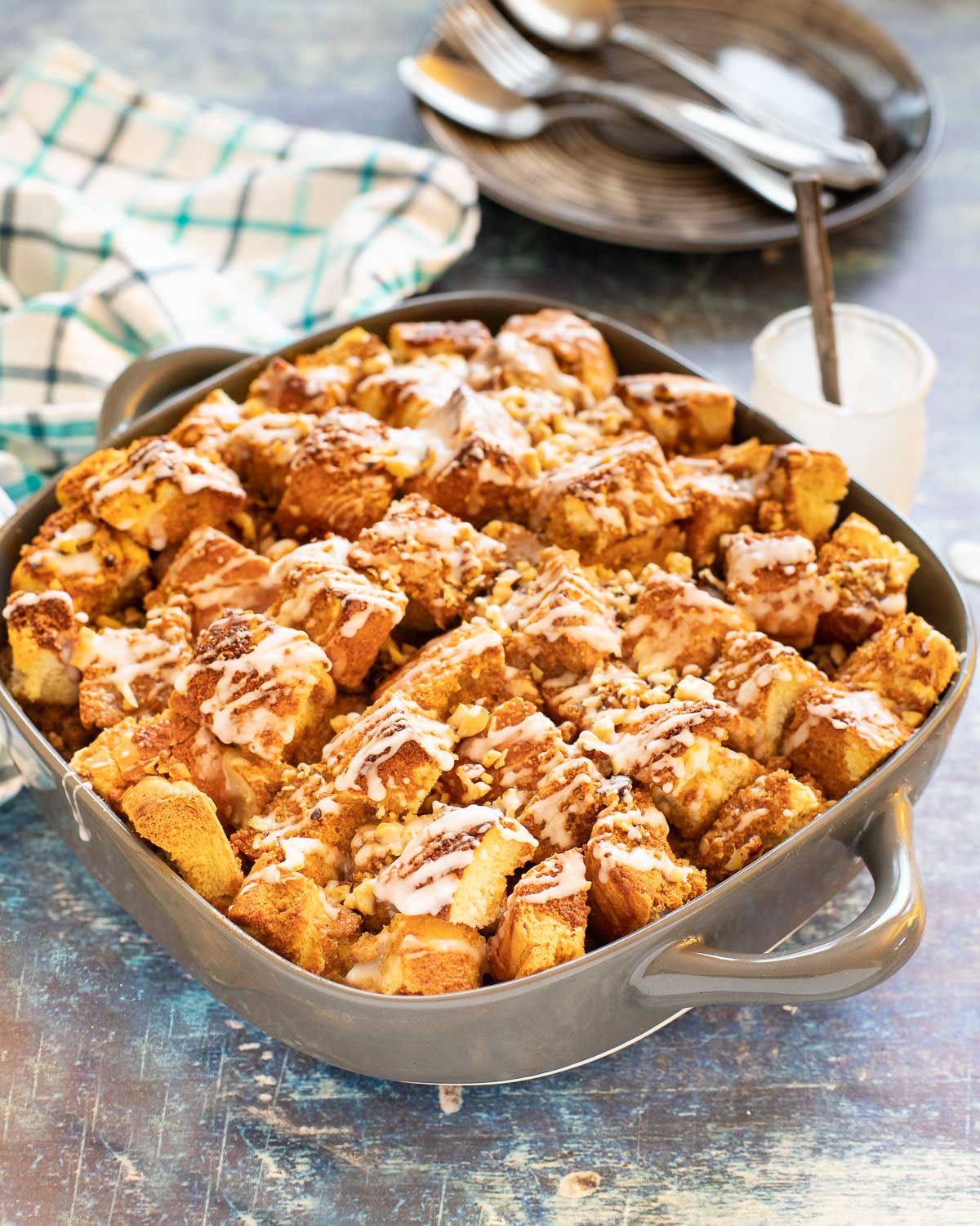 French toast casserole in a grey dish on a blue backdrop