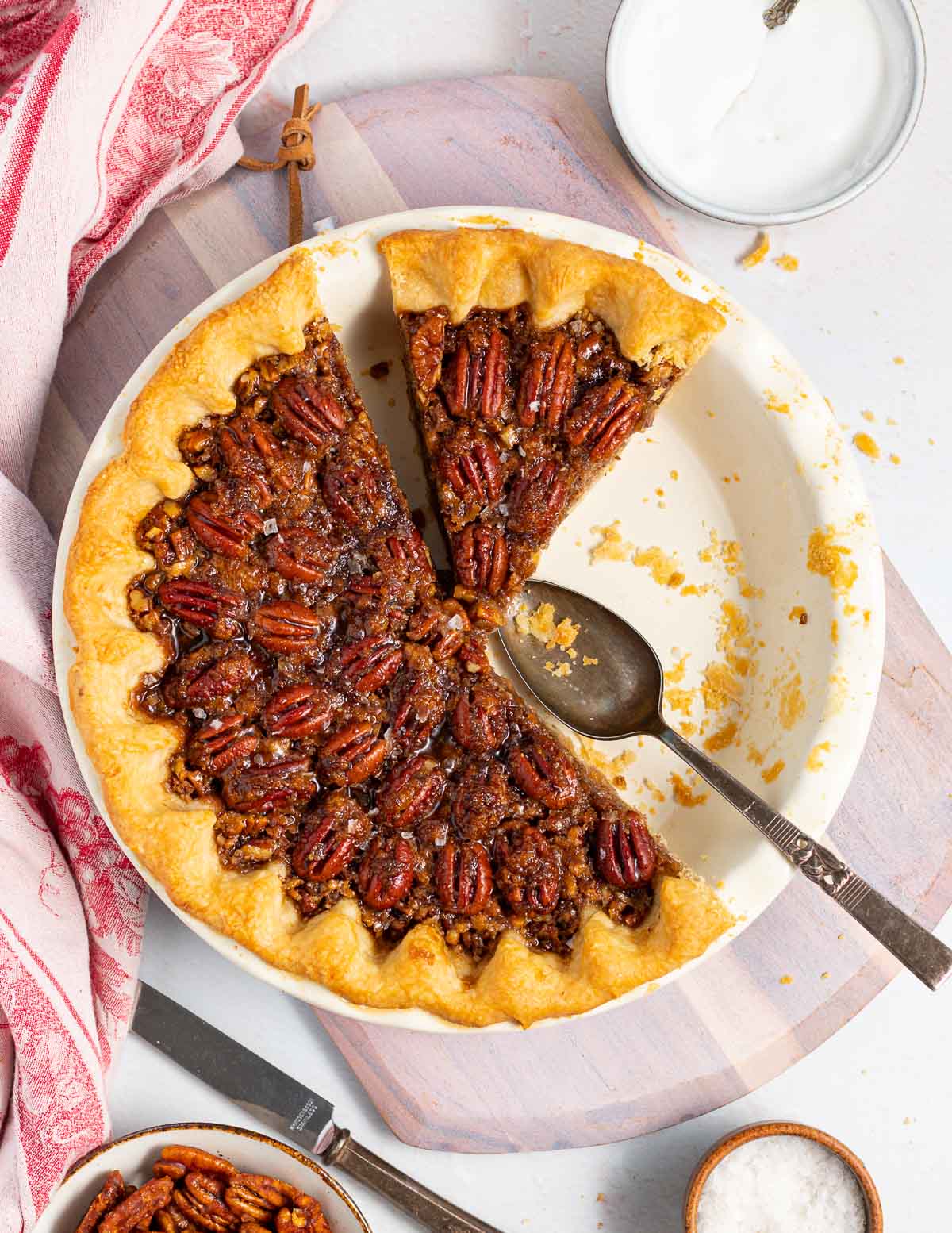 a cut pecan pie with a few slices missing in a pie dish 