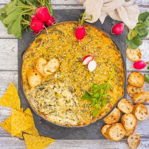 a skillet of vegan spinach artichoke dip