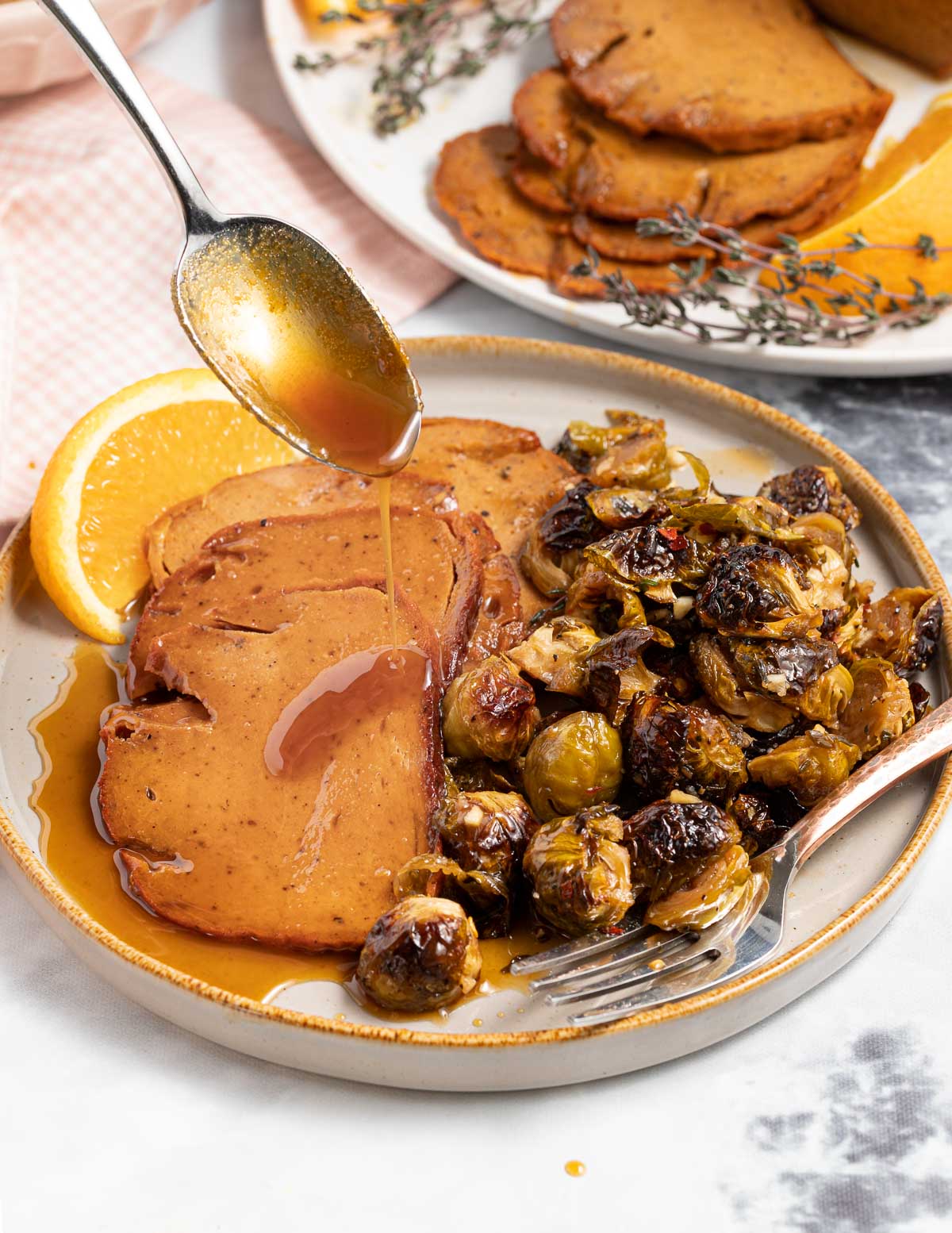 a plate of vegan ham and caramelized brussels sprouts with gravy 