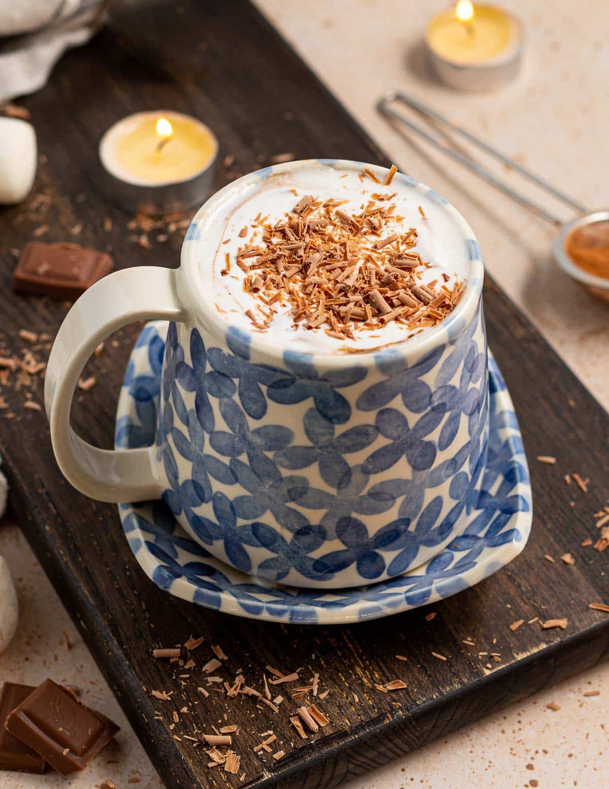 a mug of hot chocolate with cream and chocolate curls