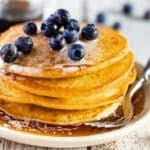 a stack of corn flour pancakes with blueberries