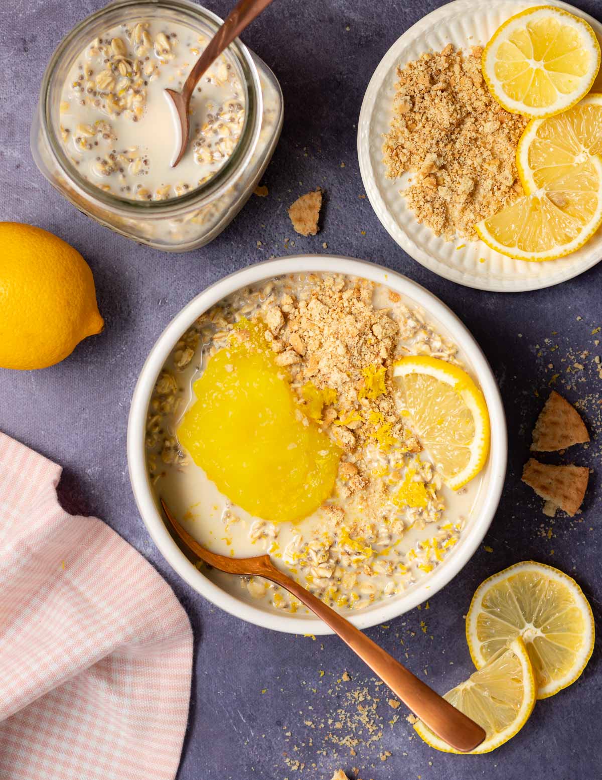 a bowl of lemon cheesecake overnight oats with lemon curd and cookie crumbles 