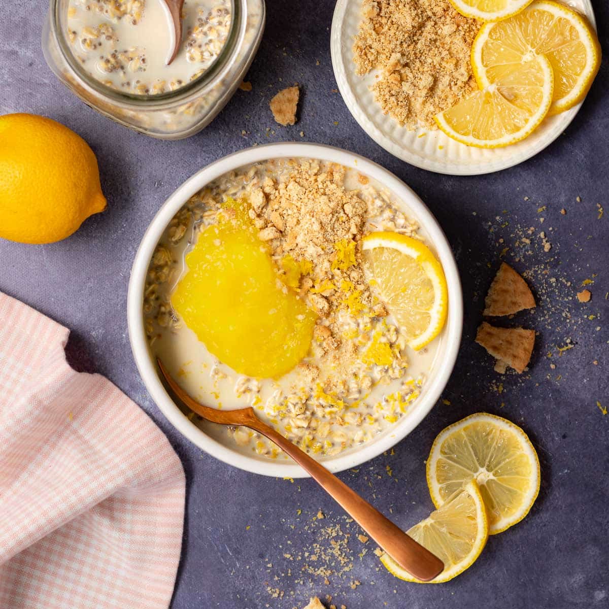 a bowl of lemon cheesecake overnight oats with lemon curd and cookie crumbles