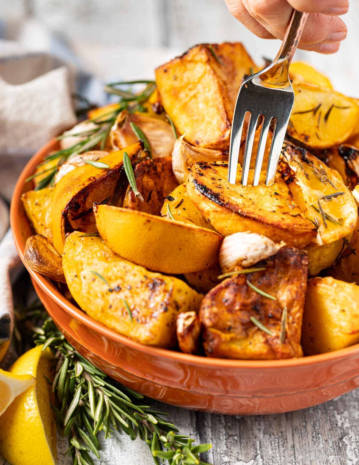 a fork being stuck into a bowl of roast potatoes