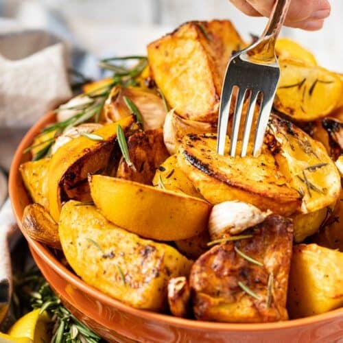 a fork being stuck into a bowl of air fryer roast potatoes