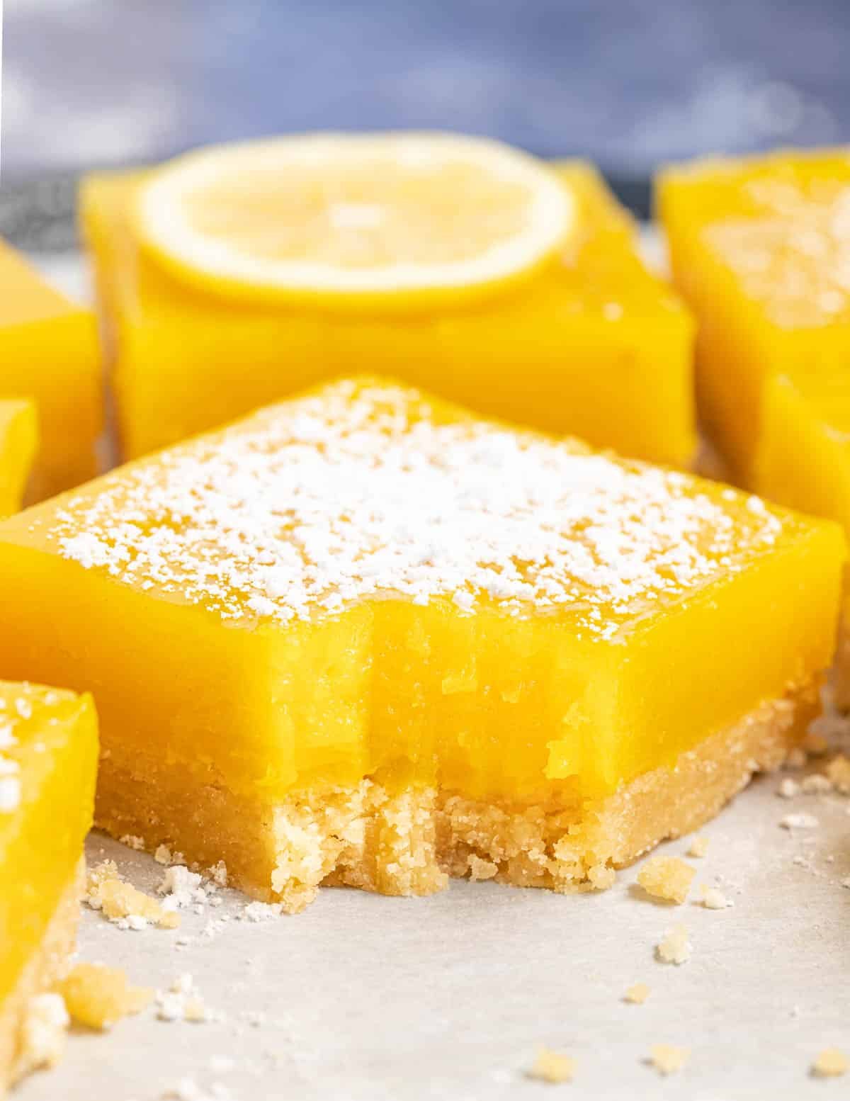 close up of a lemon bar with a bite taken off the corner