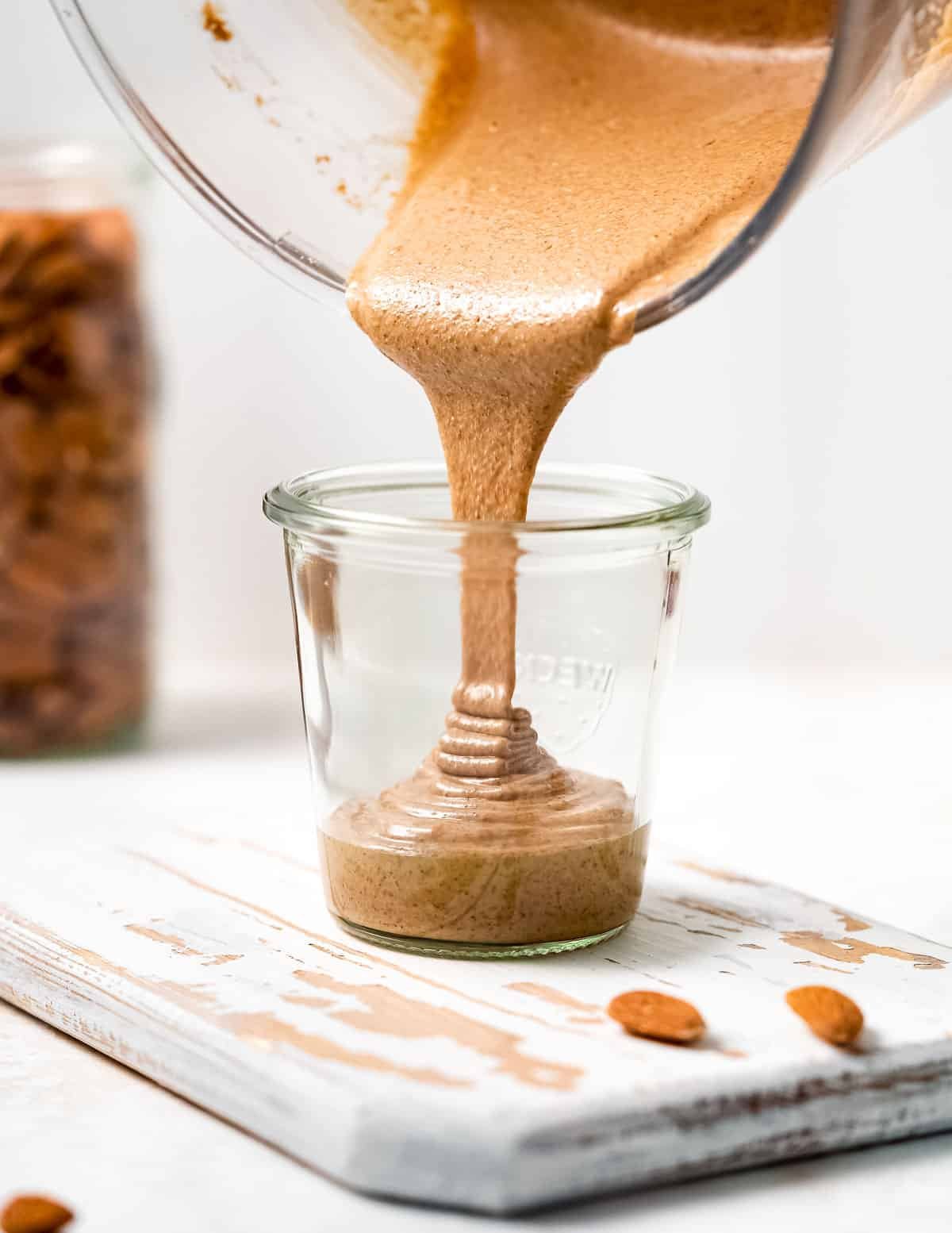 almond butter pouring into a jar 