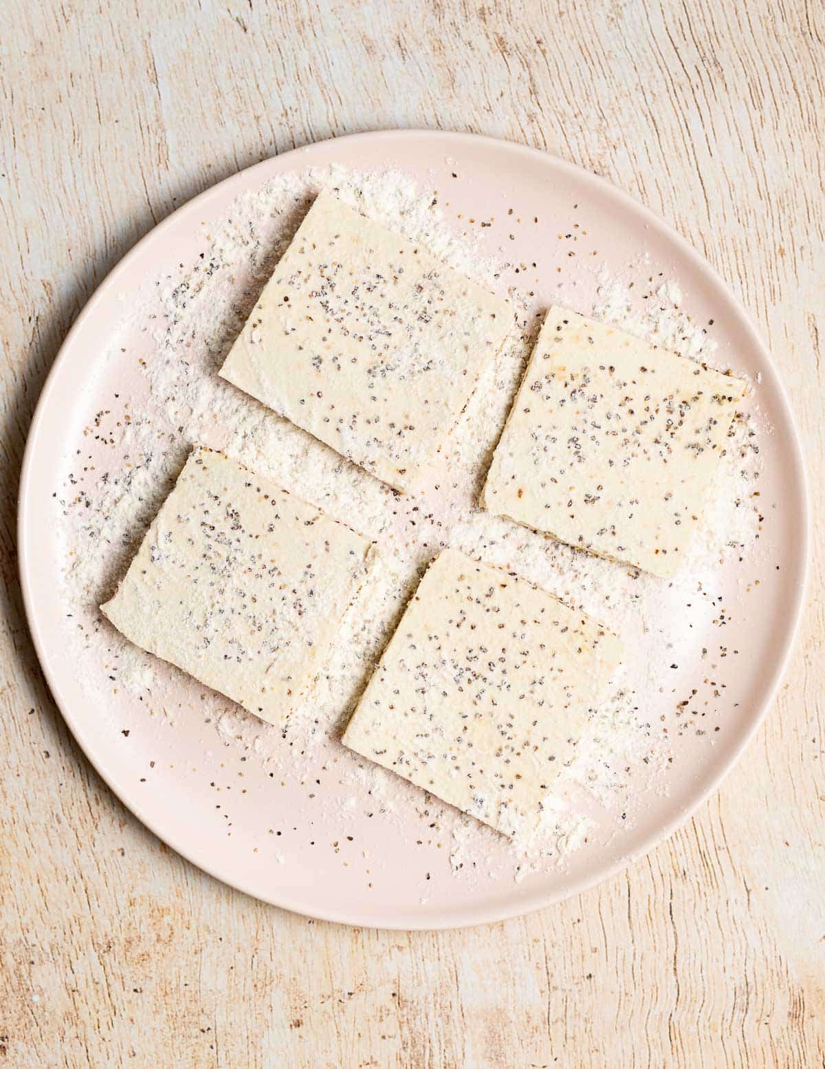 floured and seasoned tofu squares on a plate