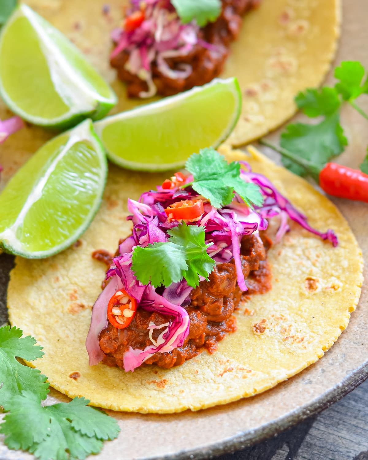 a tortilla topped with spicy lentil mixture and red cabbage slaw