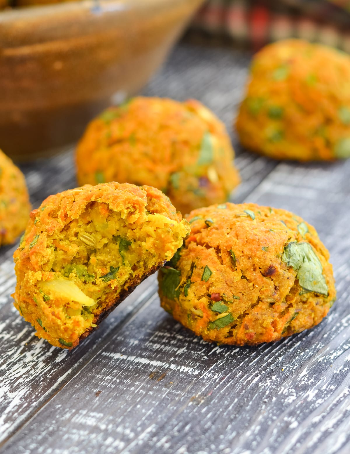 2 curried carrot falafel, one with a bite taken