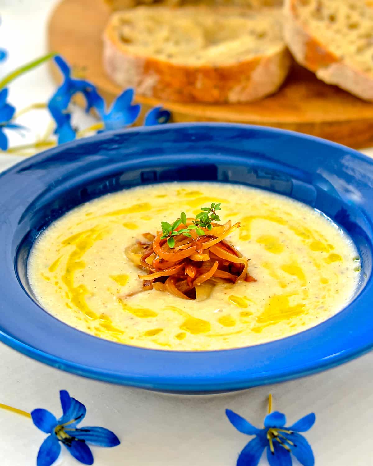 a bowl of vegan cauliflower soup topped with caramelized onions & thyme 
