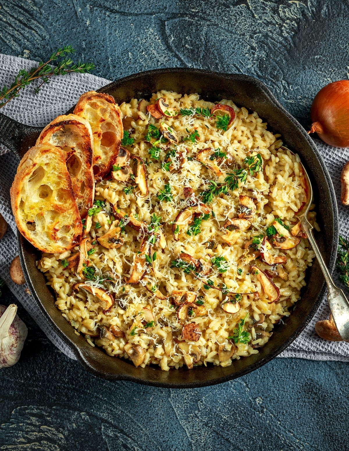 a pan of vegan garlic mushroom risotto with garlic bread 