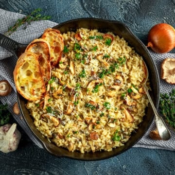a pan of vegan garlic mushroom risotto with garlic bread