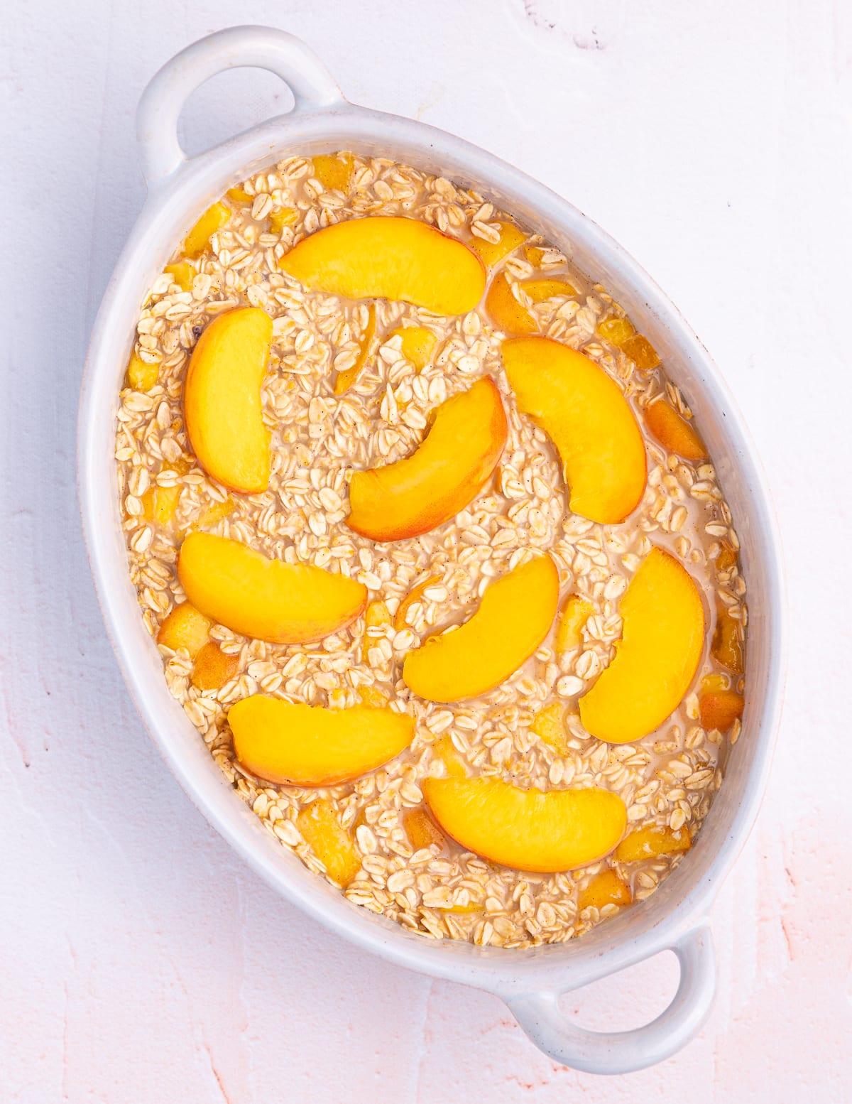 uncooked peach baked oatmeal in a ceramic dish