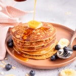 a stack of vegan banana oatmeal pancakes with v vegan butter and maple syrup