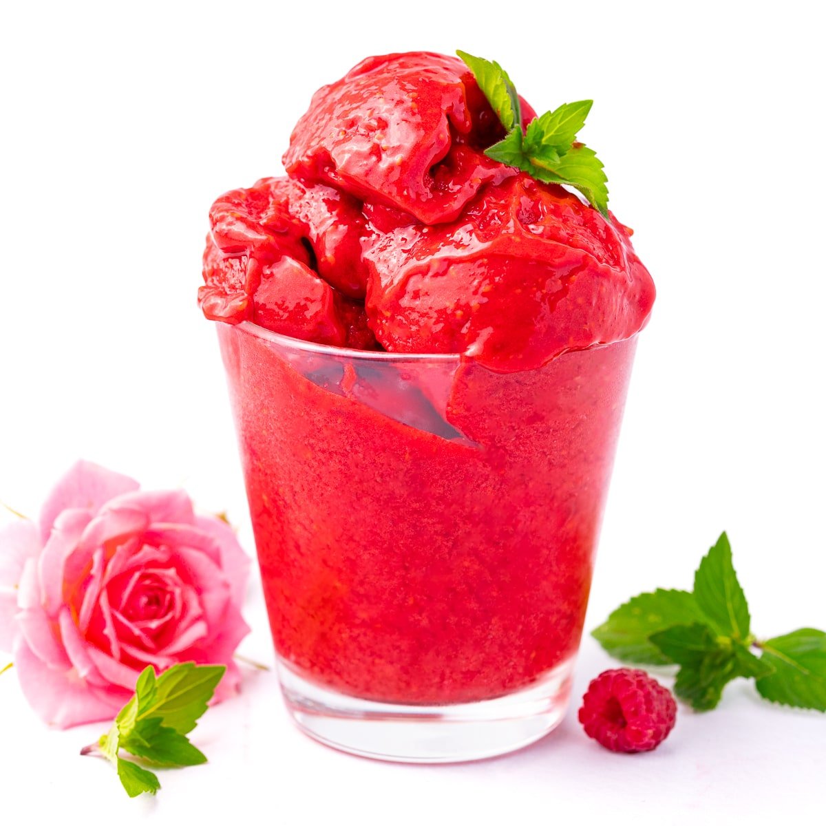 a glass of no churn raspberry sorbet garnished with a piece of mint
