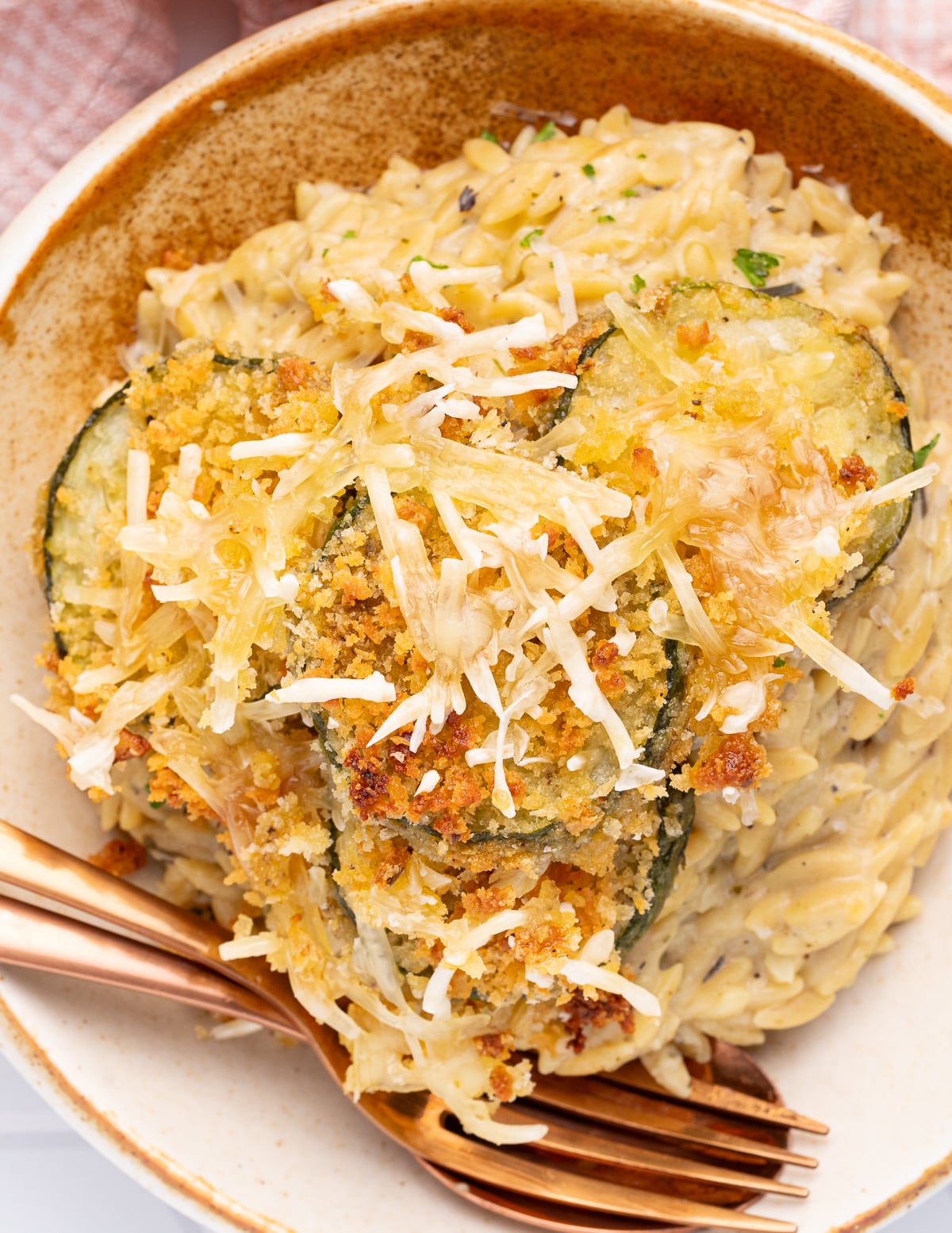 crispy bake zucchini slices on a bowl of orzo risotto