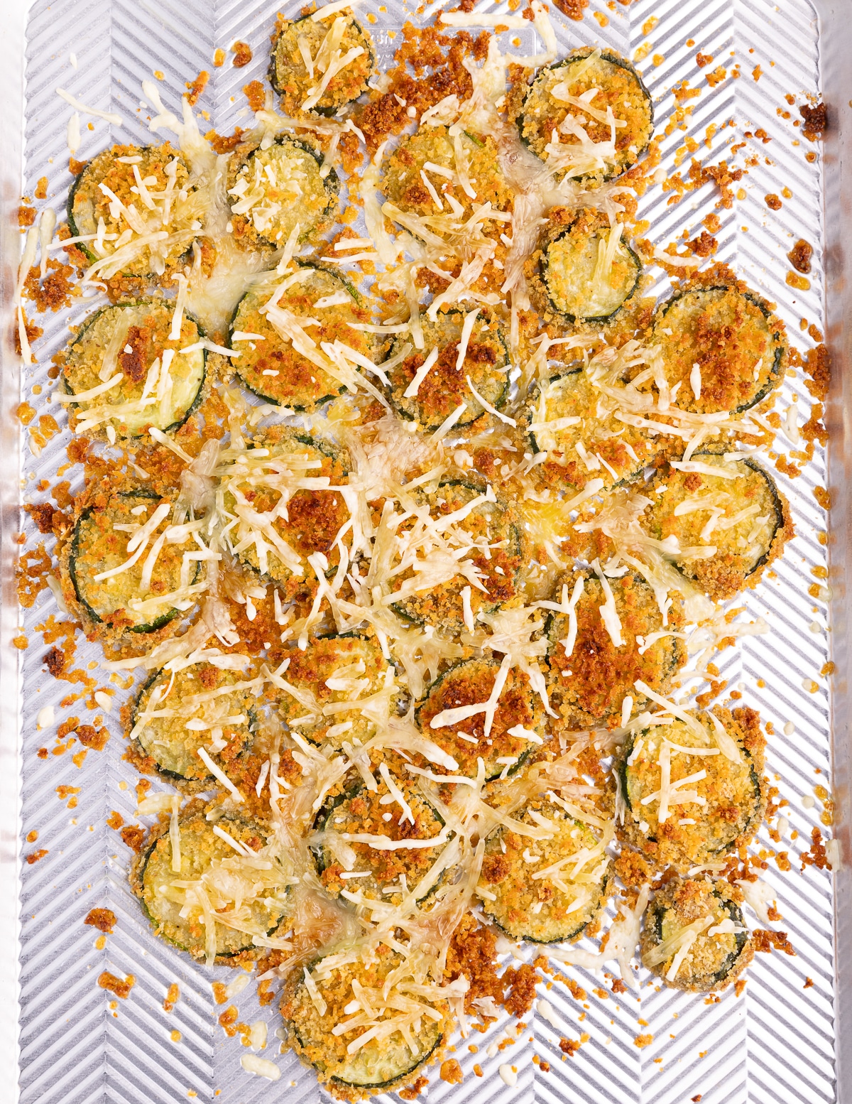 crispy, cheesy zucchini slices on a baking tray