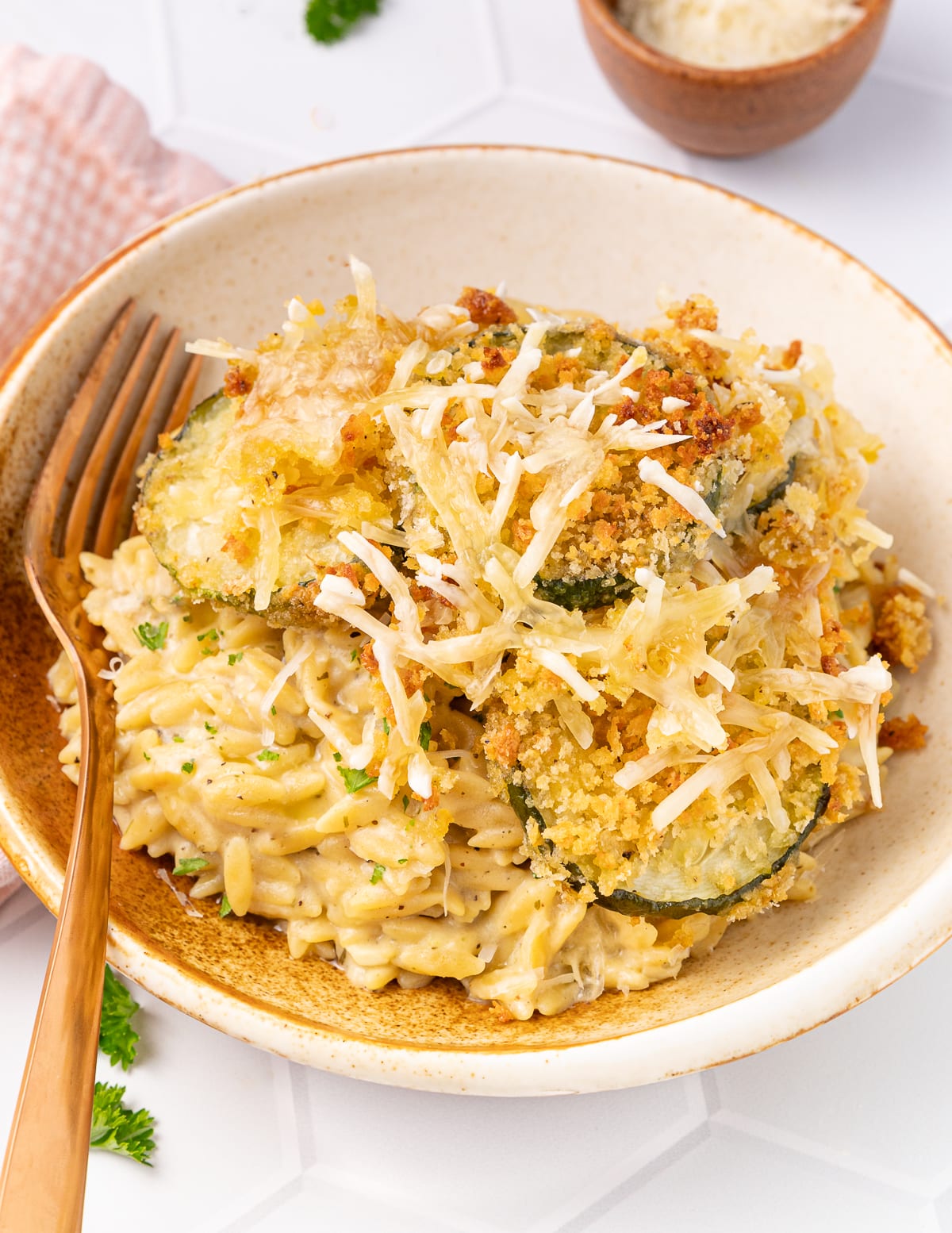 a bowl of orzo risotti with crispy zucchini slices