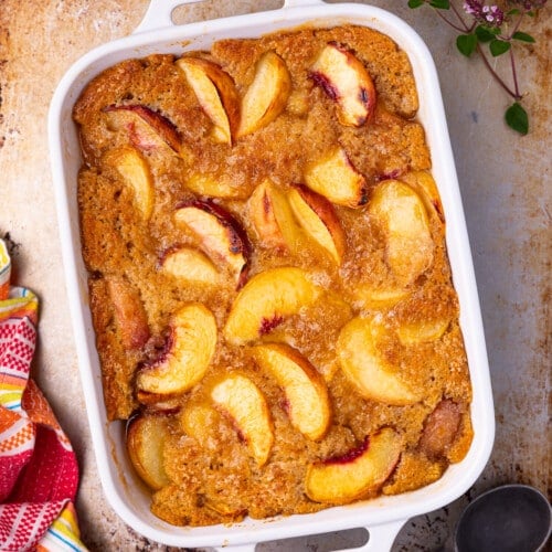 a white ceramic dish of vegan peach cobbler