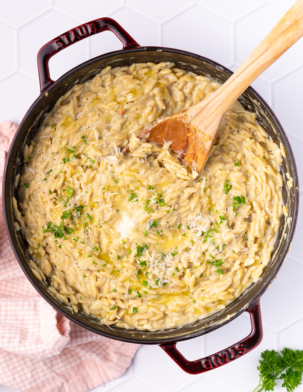 a pan of creamy orzo garnished with parsley & vegan parmesan
