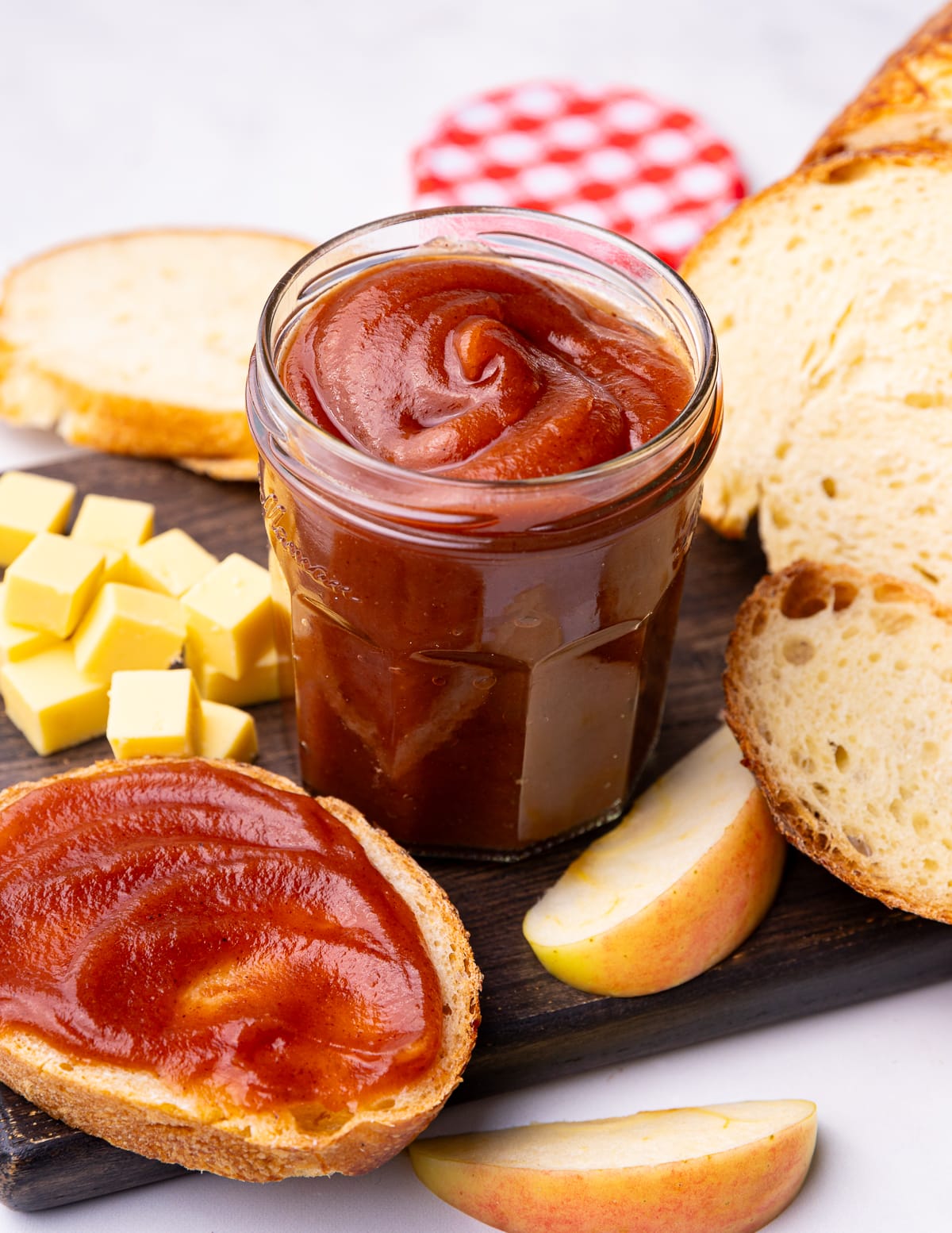 a jar of apple butter with bread and cheese