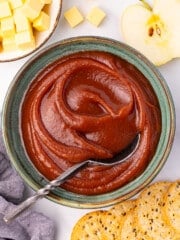 a bowl of stovetop apple butter with crackers and vegan cheese
