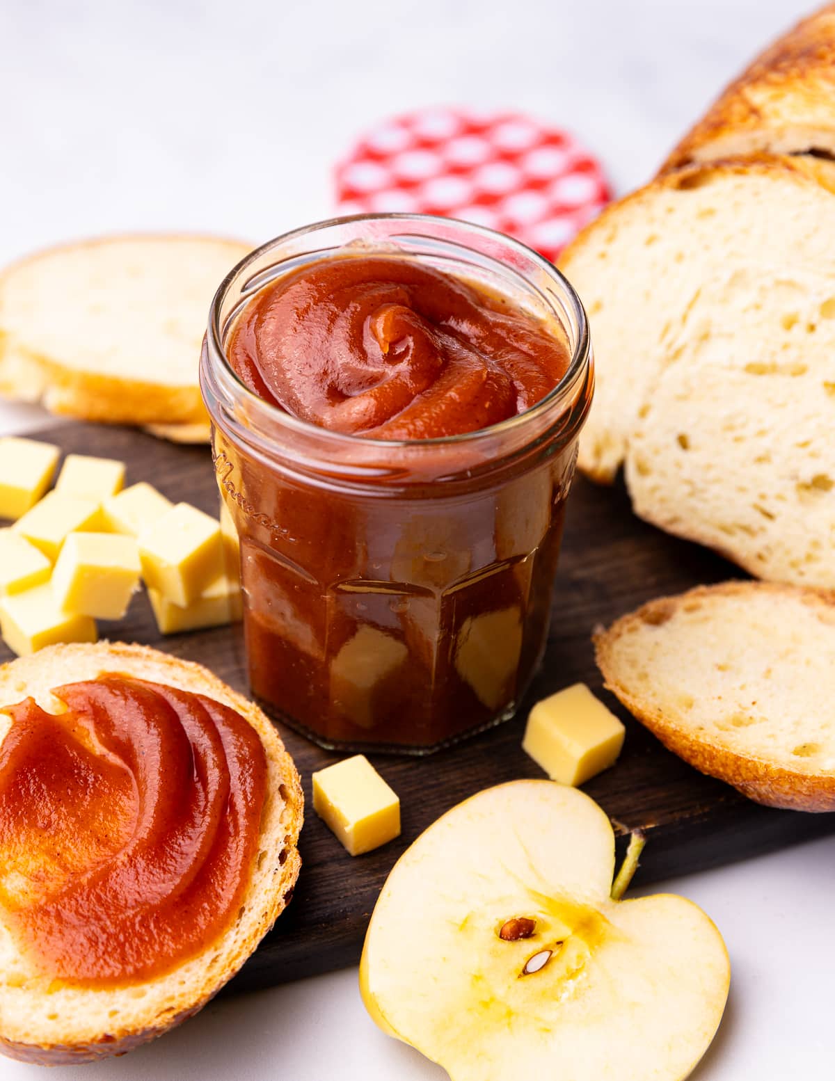 a jar of stovetop apple butter on a board with bread